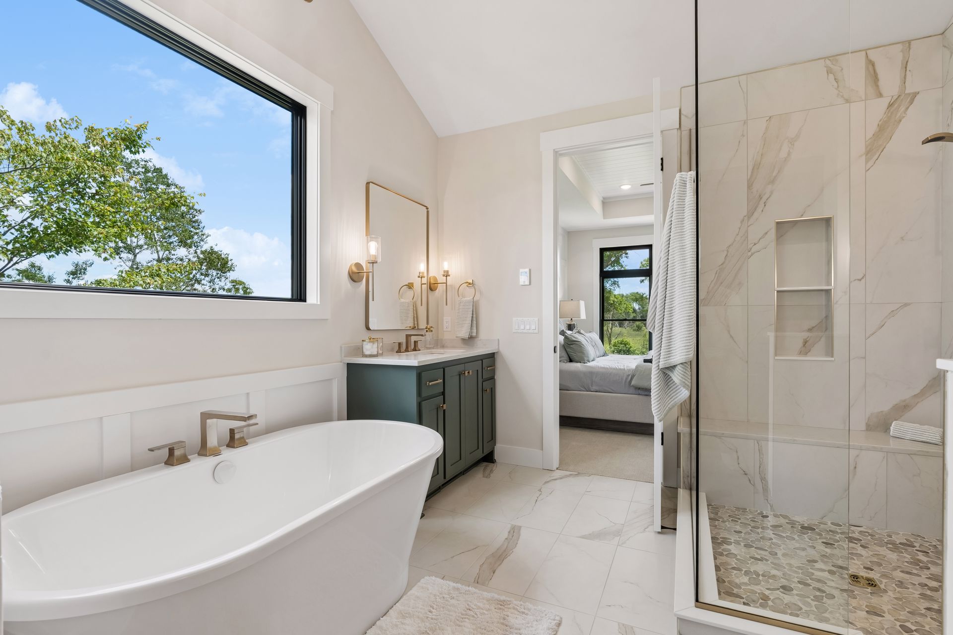 Primary bathroom with freestanding soaking tub, walk-in shower and large picture window